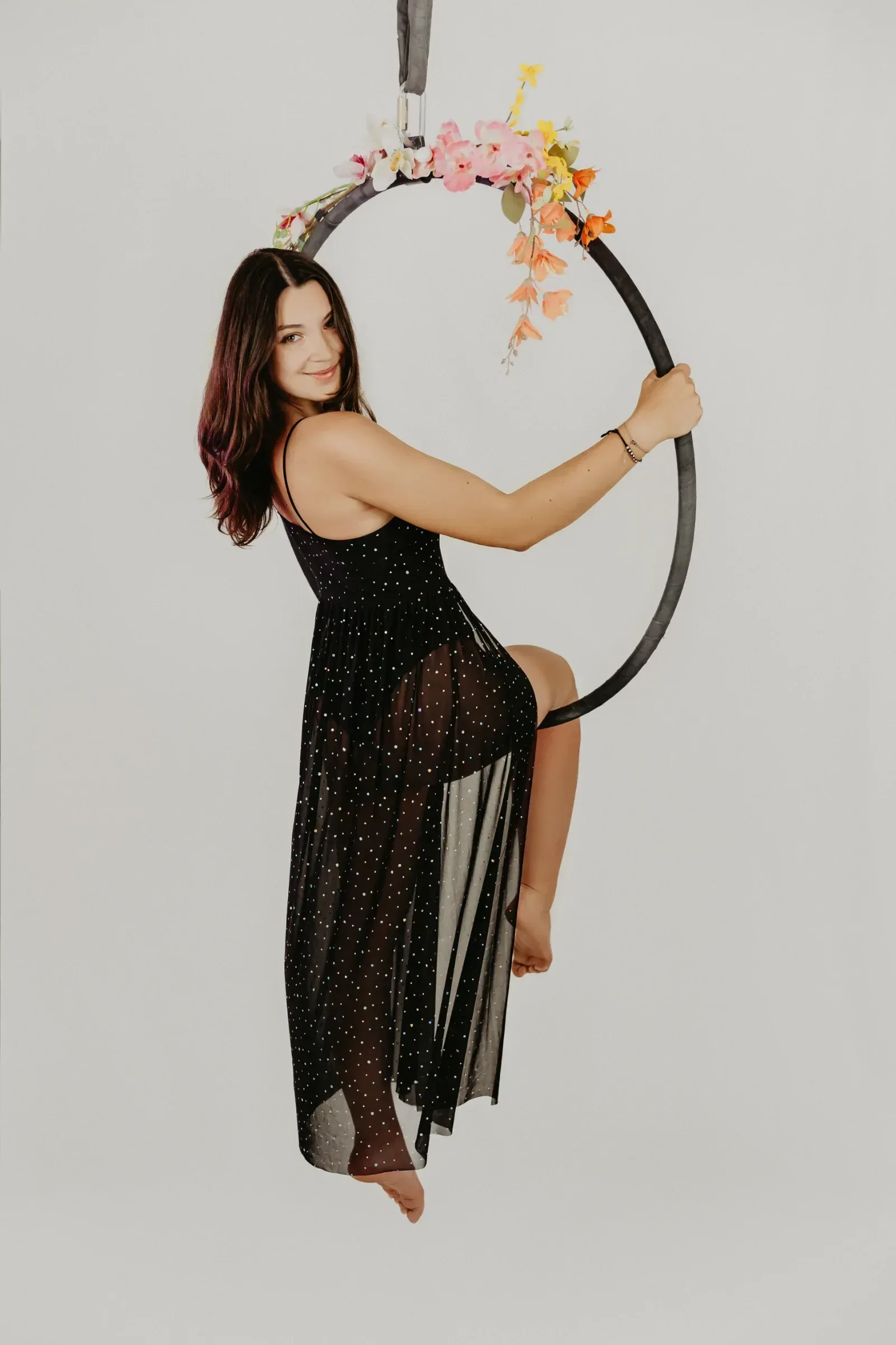 Aerial hoop – lektorka pózuje na ozdobeném kruhu s úsměvem ve studiu Prostě se hýbej, Opava.
