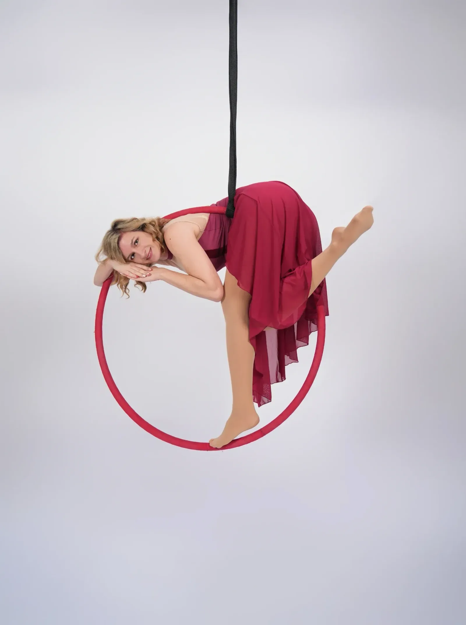 Aerial hoop – lektorka leží uvolněně uvnitř kruhu, usmívá se do objektivu ve studiu Prostě se hýbej, Opava.