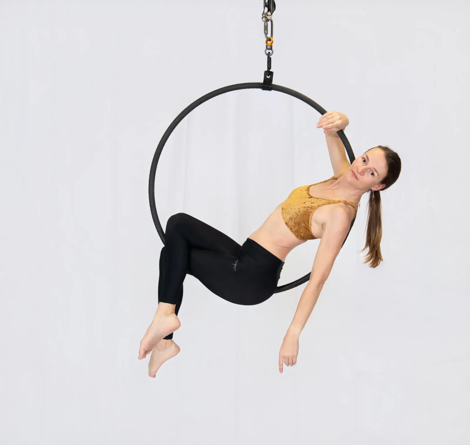 Aerial hoop – lektorka visí v kruhu v ladné pozici ve studiu Prostě se hýbej, Opava.