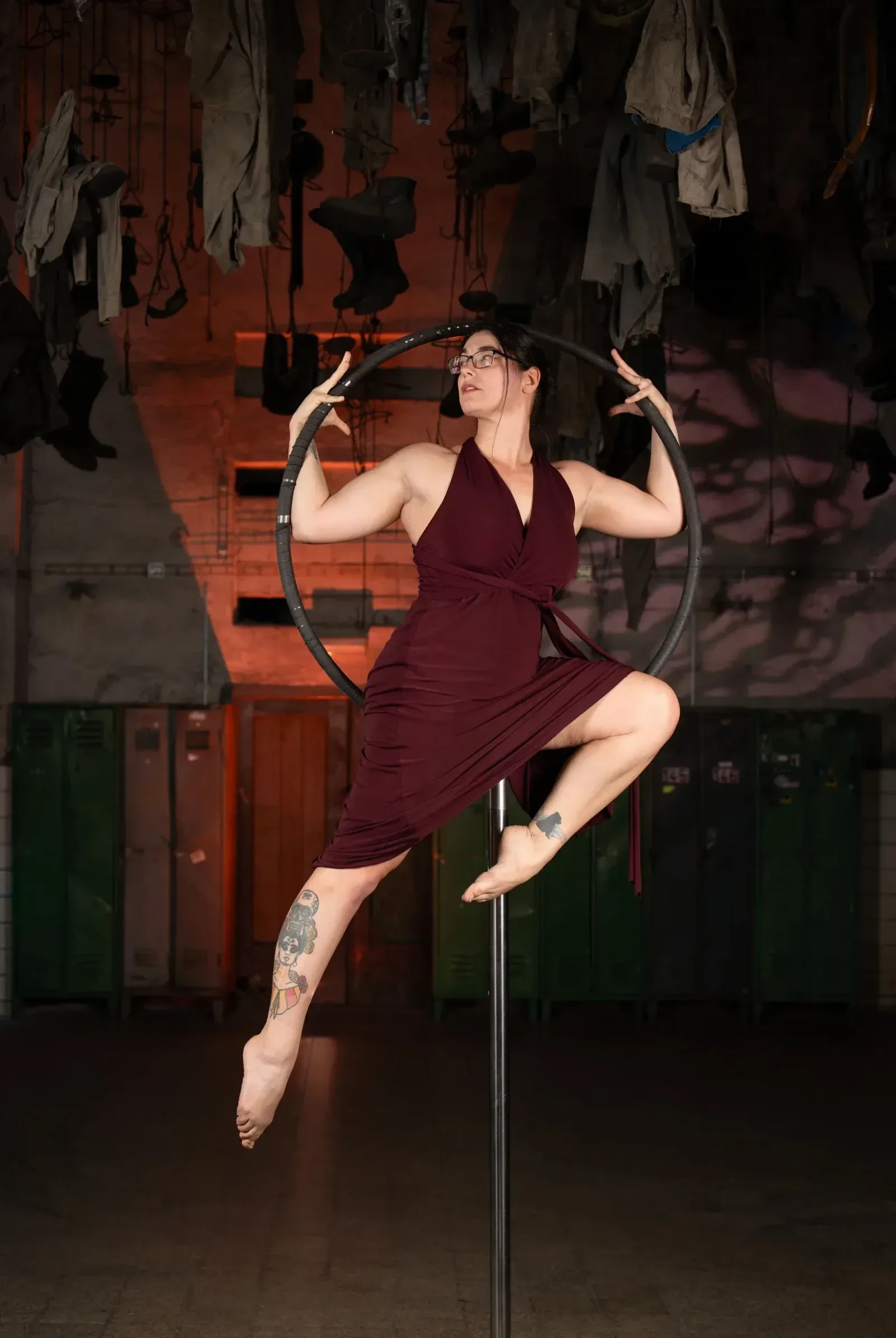 Aerial hoop – lektorka předvádí elegantní pozici v kruhu s nohou opřenou o tyč ve studiu Prostě se hýbej, Opava.