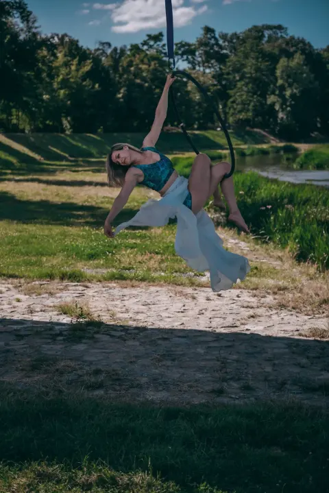 Aerial hoop – lektorka provádí ladný akrobatický trik zavěšená ve vzdušném kruhu ve studiu Prostě se hýbej, Opava.