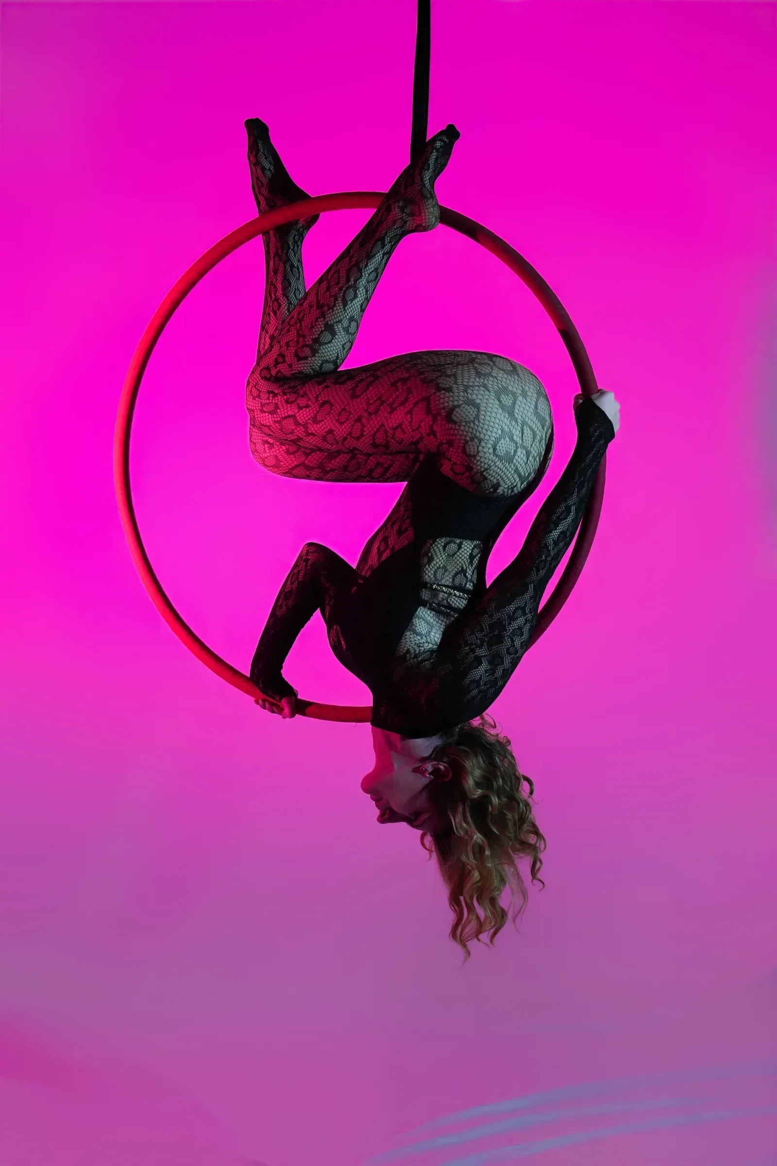 Aerial hoop – lektorka visí hlavou dolů v obruči se zkříženýma nohama ve studiu Prostě se hýbej, Opava.