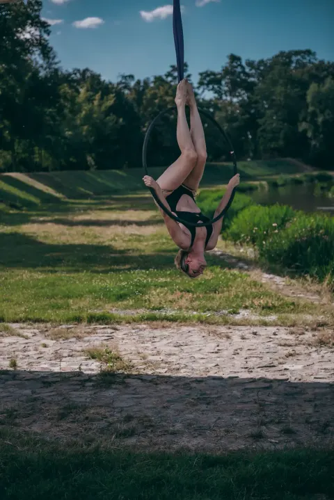 Aerial hoop – lektorka visí na kruhu hlavou dolů a drží se ho rukama ve studiu Prostě se hýbej, Opava.