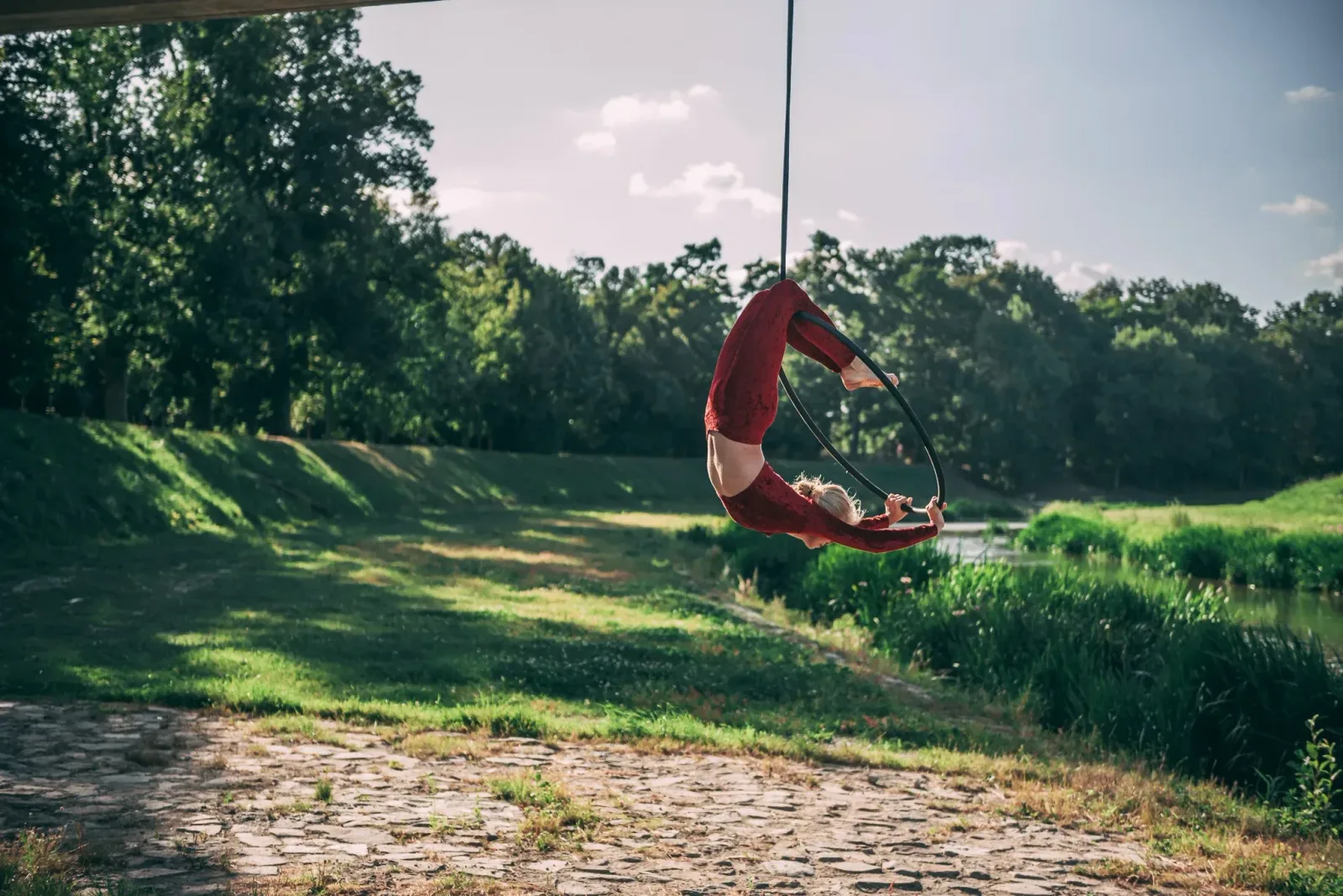 Aerial hoop – lektorka visí v kruhu hlavou dolů s prohnutým tělem ve studiu Prostě se hýbej, Opava.