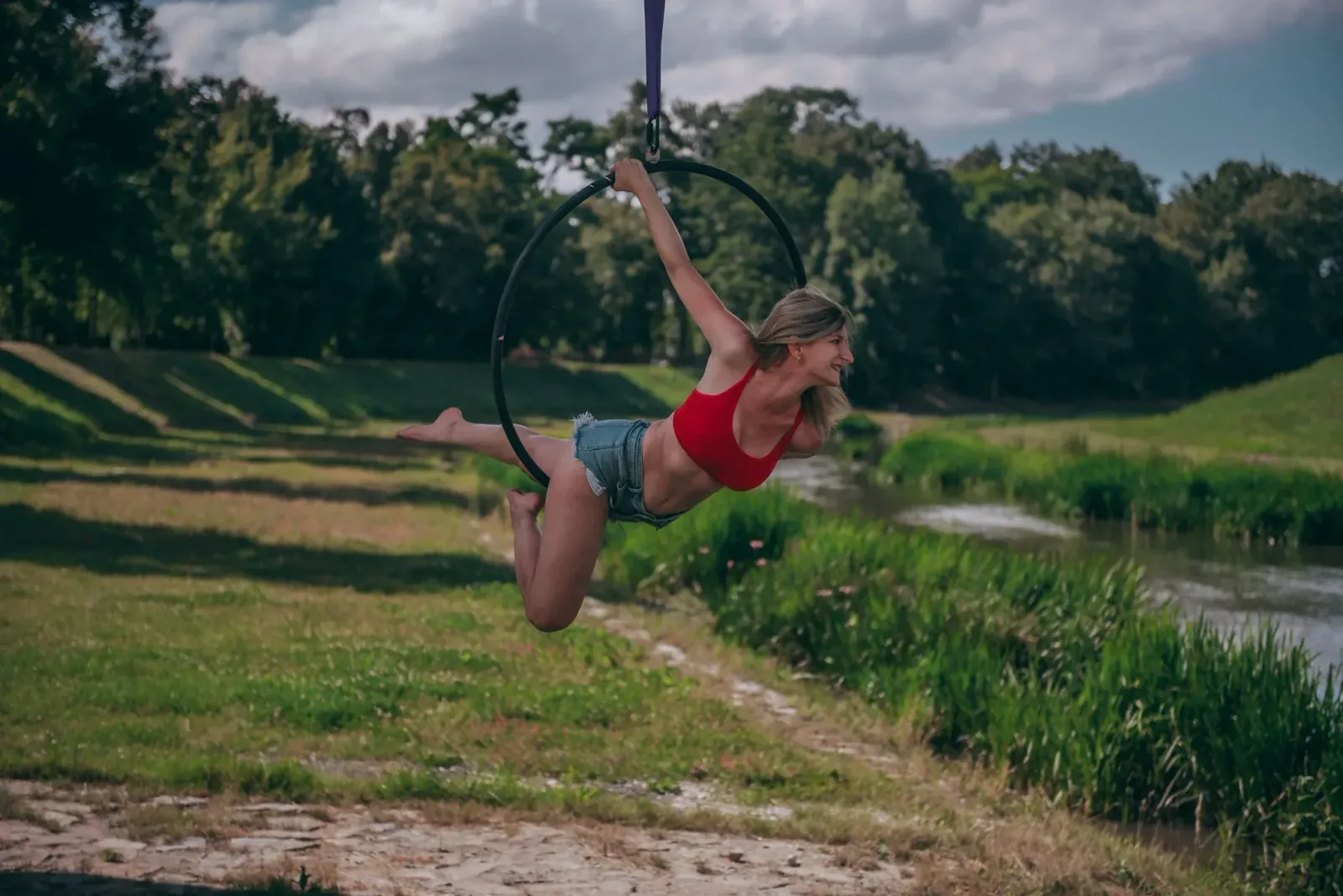 Aerial hoop – lektorka visí vodorovně v kruhu s úsměvem ve studiu Prostě se hýbej, Opava.