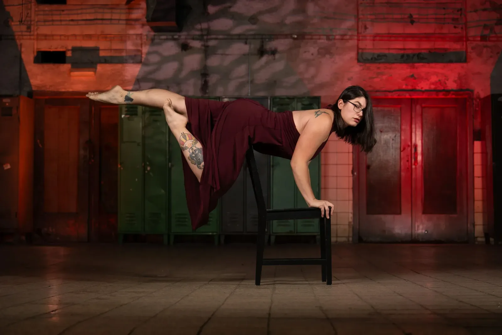 Chairdance – lektorka provádí náročnou akrobatickou pózu balancující na židli s nataženýma nohama ve studiu Prostě se hýbej, Opava.