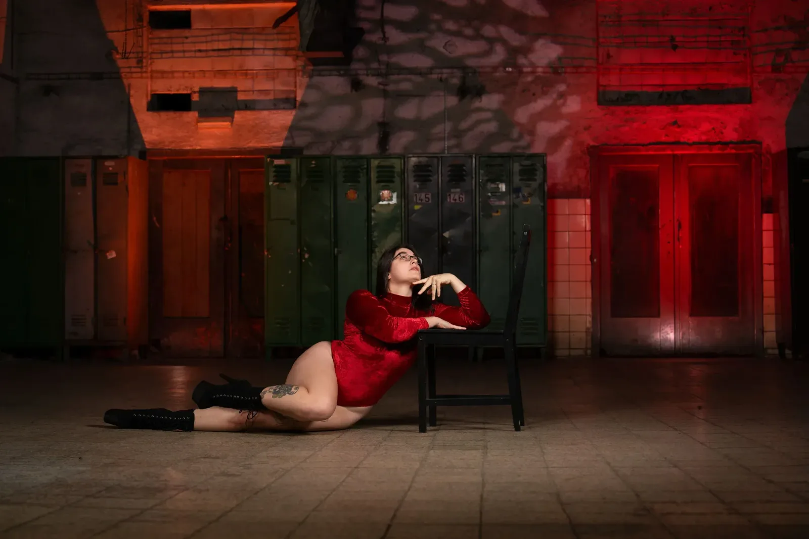 Chairdance – lektorka v červeném body leží na zemi opřená o židli a dívá se vzhůru ve studiu Prostě se hýbej, Opava.