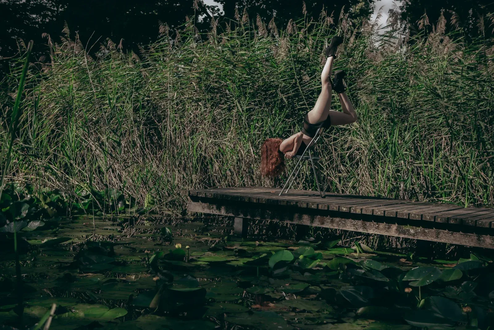 Chairdance – žena akrobaticky visí na židli s nohama vzhůru ve studiu Prostě se hýbej, Opava.